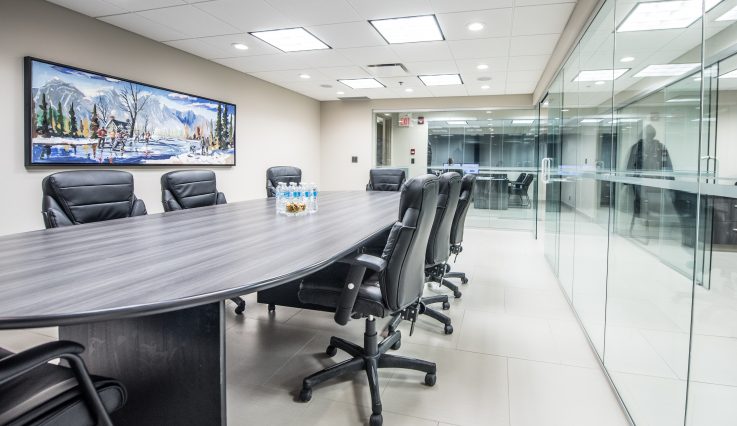 Boardroom office with flatscreen and glass walls.