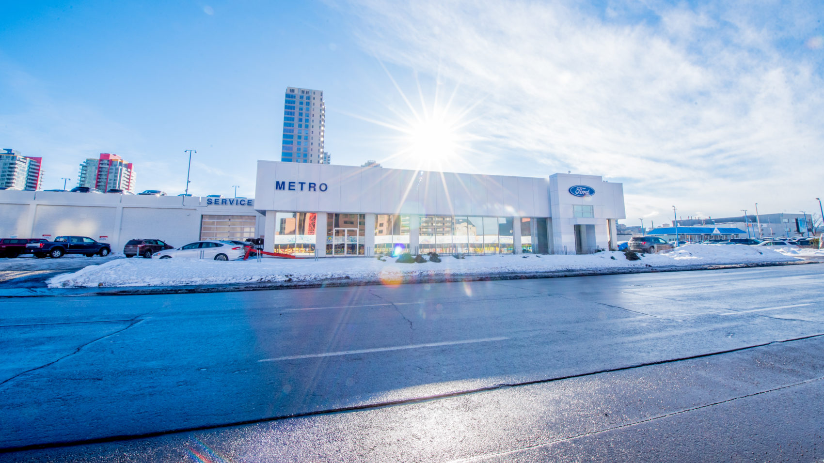 Exterior white building with snow on the ground at Metro Ford.