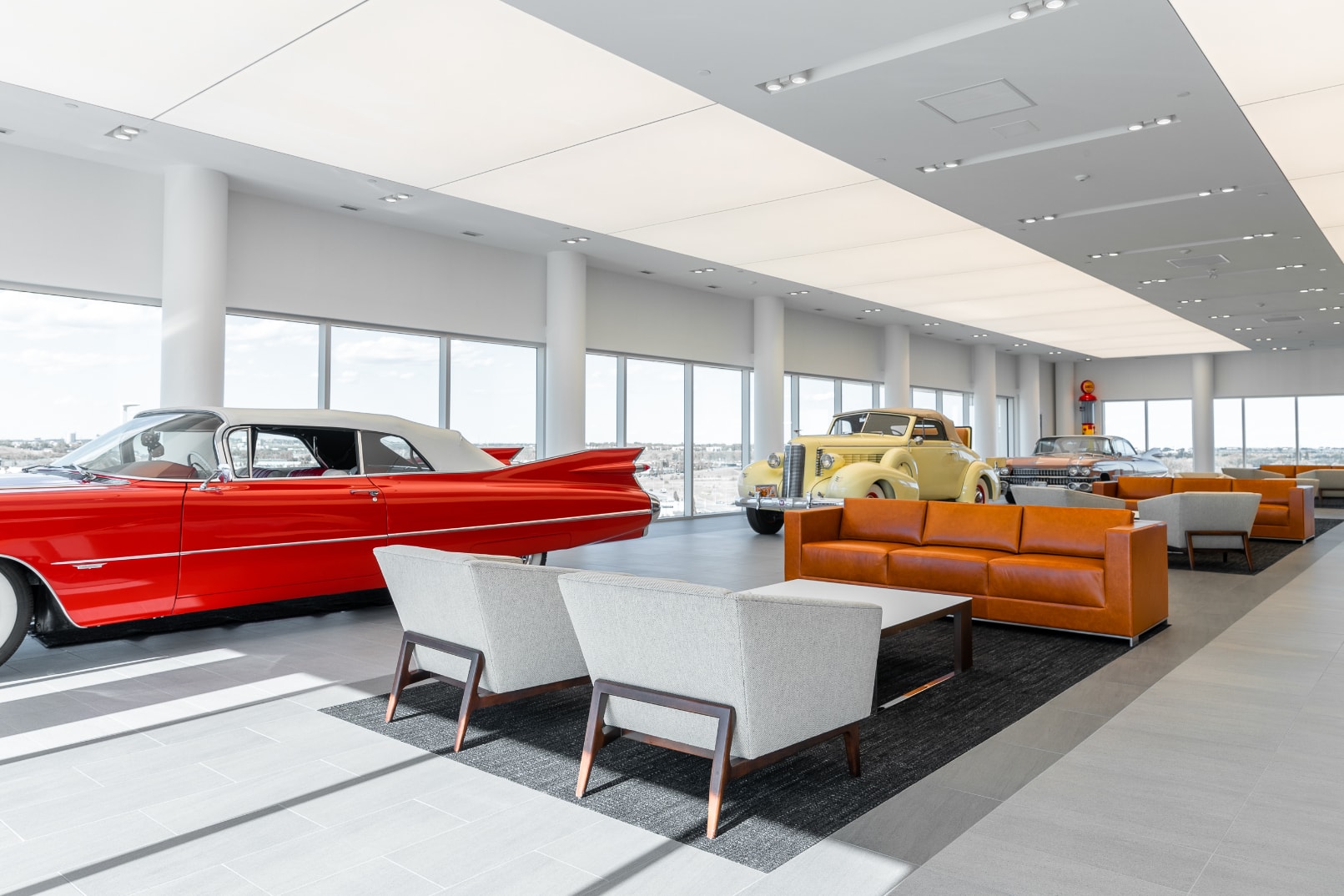 Customer seating area with cars surrounding in the showroom at Carter Cadillac.